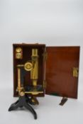 A mid 20th century microscope by Baker 244 High Holborn, London in a mahogany carrying case. H.30