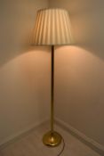 A brass plated standard lamp with shade raised on circular foot. H.164.5 Shade Dia. 50cm