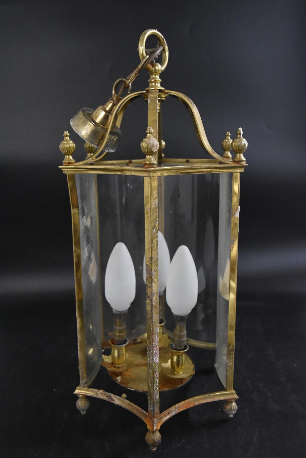 A contemporary brass and inverted glass hexagonal hanging hall lantern with three lightbulb