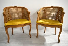 A pair of 20th century French style beech framed bergère armchairs with yellow cushion seats. H.87