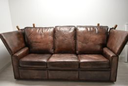 A contemporary three seater brown leather Knole settee with drop arms. H.90 W.198 D.100cm.