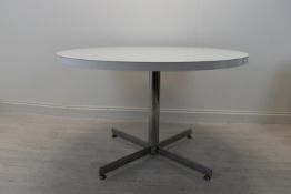 A vintage circular laminated top table on chrome plated central column with four outspread