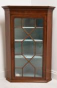 A George III mahogany single door corner cupboard with dentil cornice and single astragal glazed