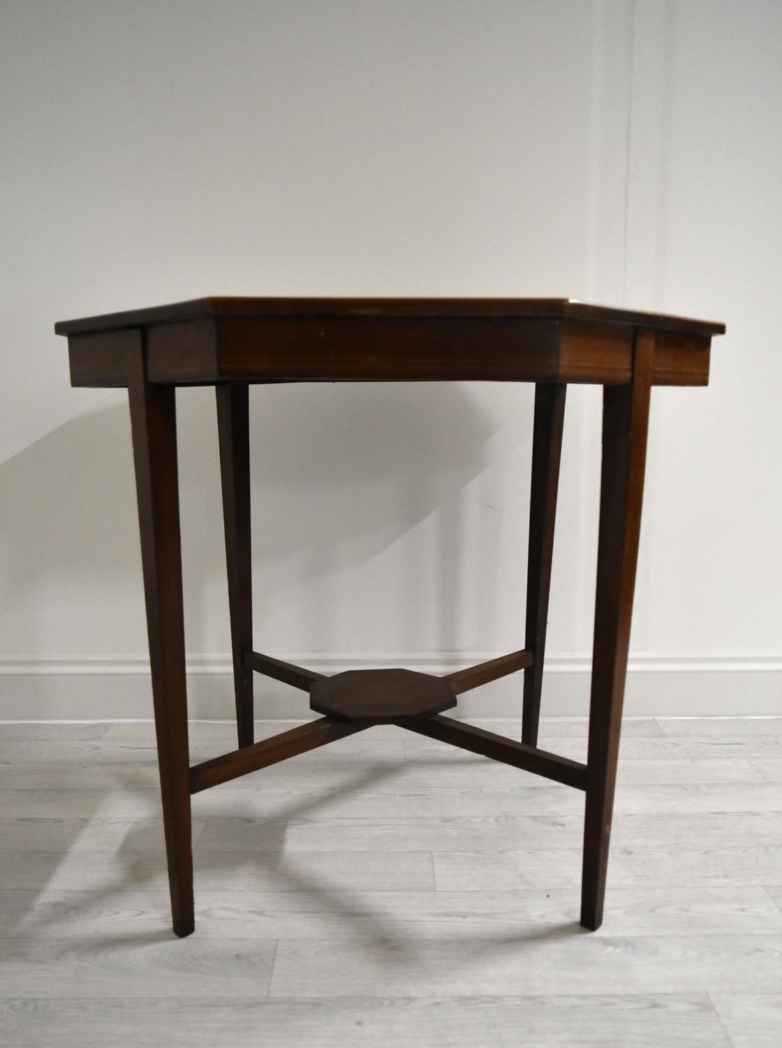 An Edwardian mahogany octagonal occasional table on tapering supports united by stretcher. H.68.5