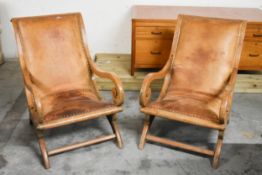 A pair of 19th century armchairs with scrolling arms upholstered in studded tan leather. H.94 x W.62