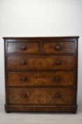 A late Victorian mahogany chest of two short over three long drawers with turned handles raised on