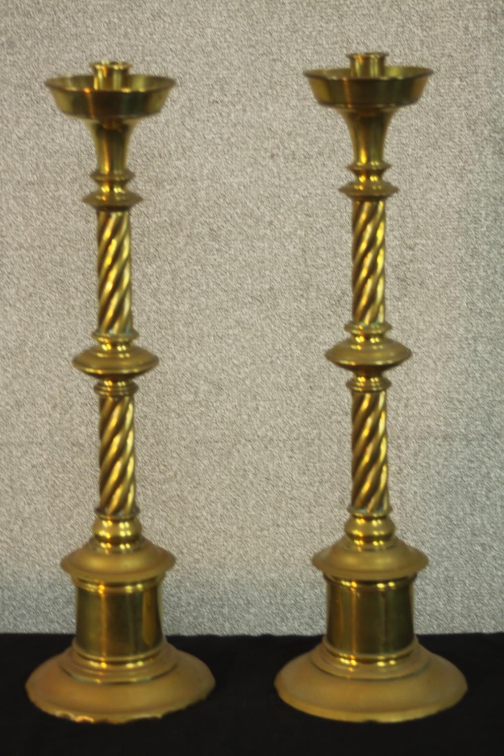 A pair of large early 20th century brass ecclesiastical twist stem floor standing candle holders