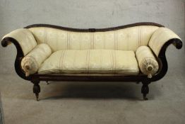 A William IV mahogany sofa, upholstered in cream fabric with a loose seat cushion and two