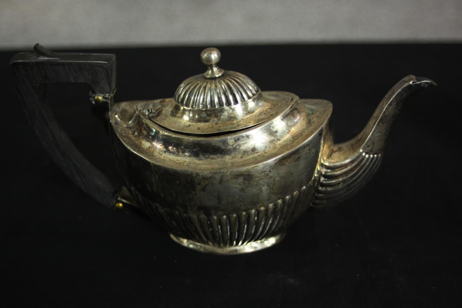 An Austrian gadrooned silver tea pot with ebony handle. Hallmarked: Austrian assay marks, maker's