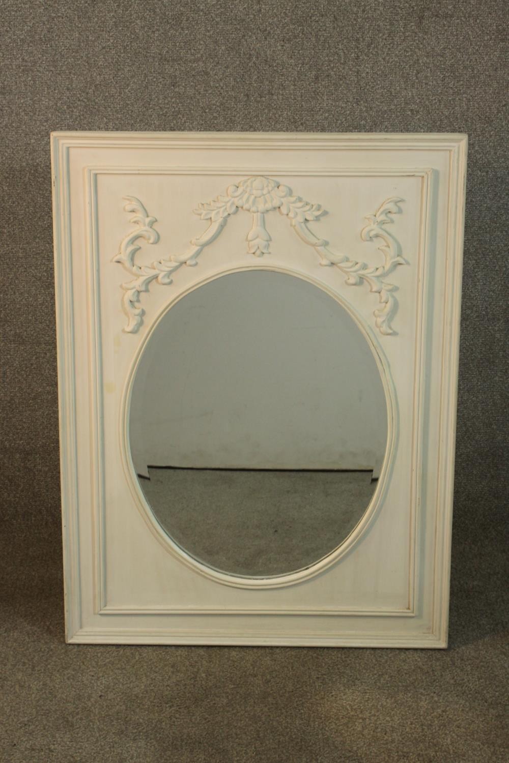 A 19th century style white painted mirror, the oval mirrored plate in a rectangular frame with