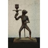 A painted spelter early 20th century candle holder in the form of a monkey holding a flower. H.31