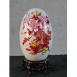 A large Chinese transfer printed and gilded floral and insect design crackle glaze ceramic egg,