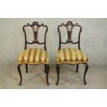 A pair of late Victorian carved walnut side chairs, the ornately carved back with a pierced splat,