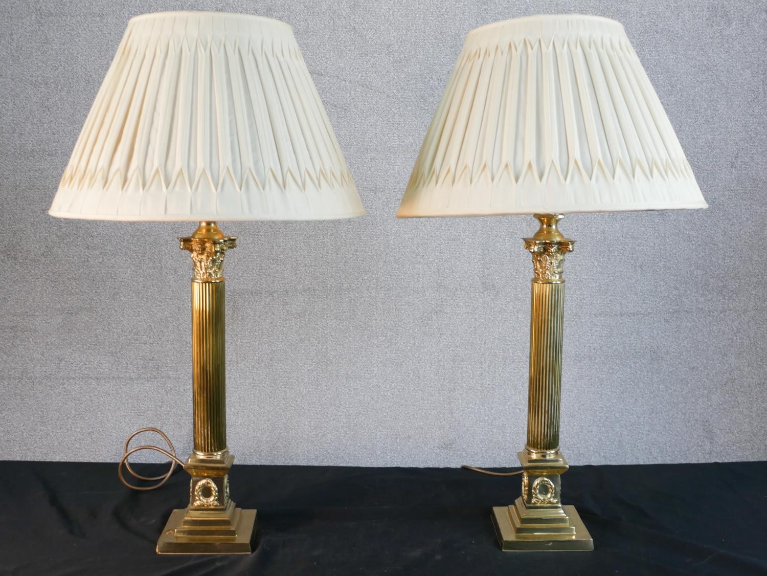 A pair of Classical brass fluted column table lamps with relief laurel wreath motifs on stepped
