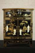 A contemporary Chinese black lacquered and parcel gilt miniature side cabinet, applied with