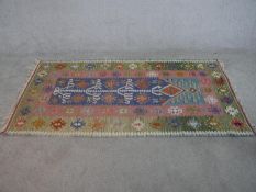 A hand made blue ground Turkish Kilim rug. W.200 D.100cm