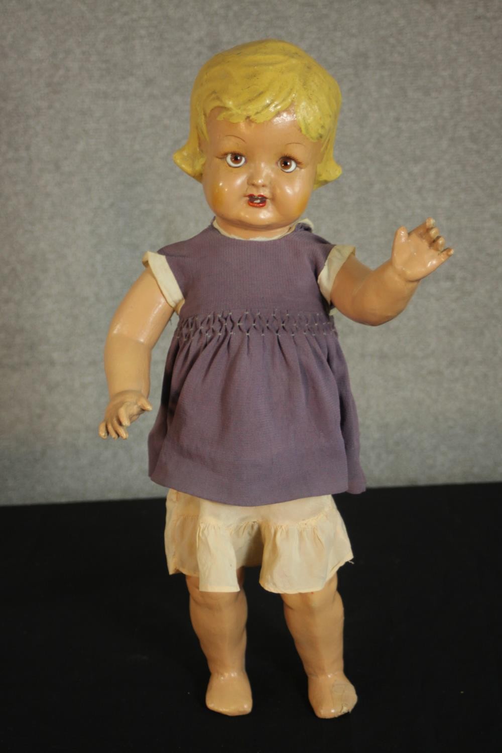 A late 19th century-early 20th century painted papier mache doll with glass eyes and voice box. (not