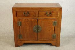 A 20th century Chinese elm side cabinet, with a single drawer over a pair of cupboard doors with