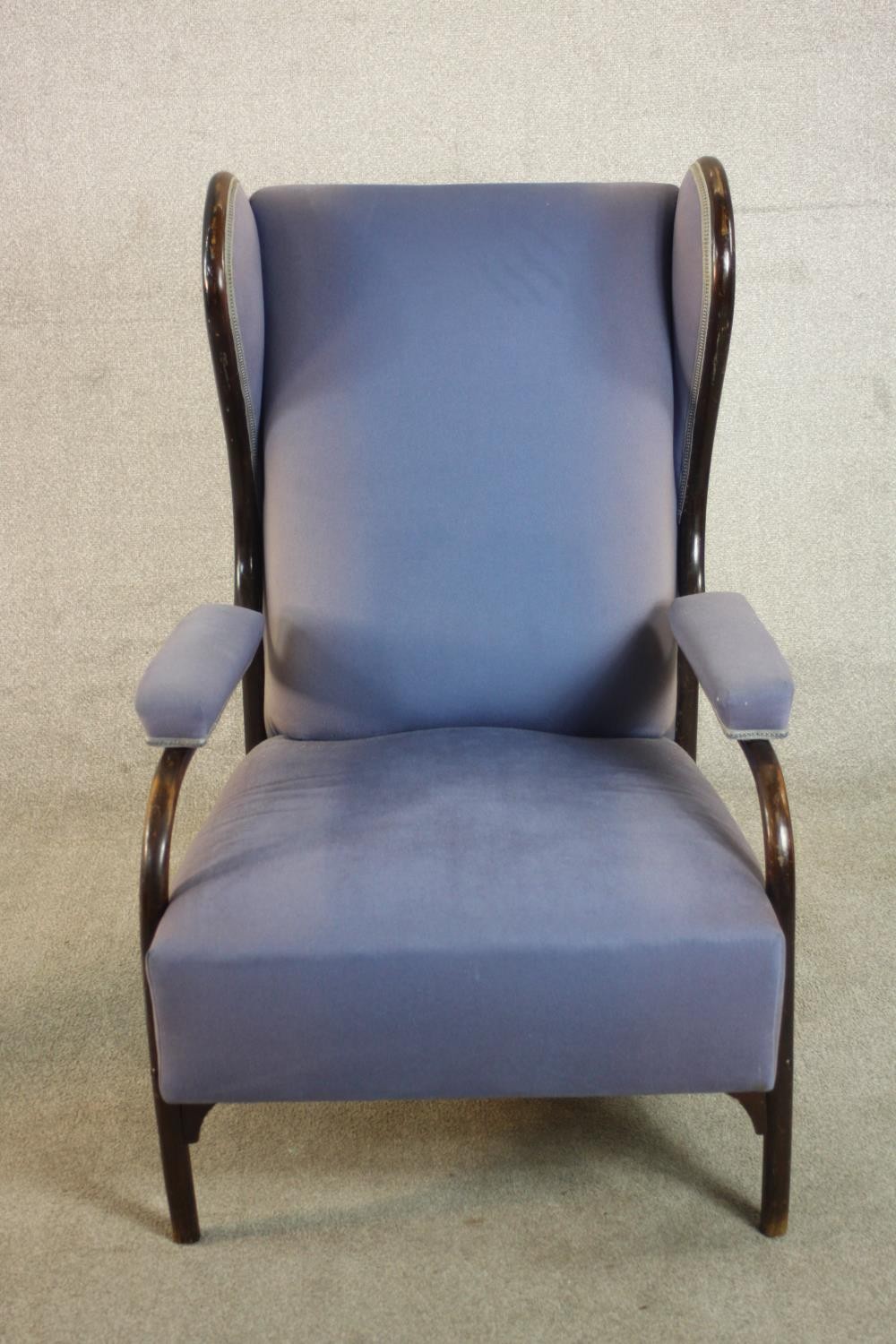 A late 19th/early 20th century bentwood wingback armchair, in the manner of Thonet, upholstered in