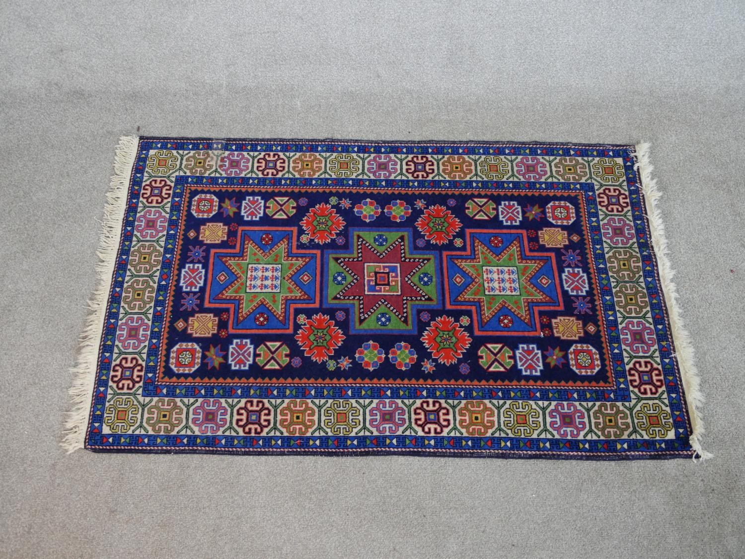 A blue ground hand made Russian Kazak rug. W.129 D.80cm