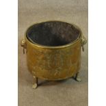 A 19th century brass coal bucket or jardiniere, with a heraldic crest to the side, lion mask handles