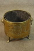 A 19th century brass coal bucket or jardiniere, with a heraldic crest to the side, lion mask handles