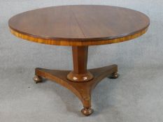 A William IV walnut circular tilt top breakfast table raised on tapering hexagonal central column