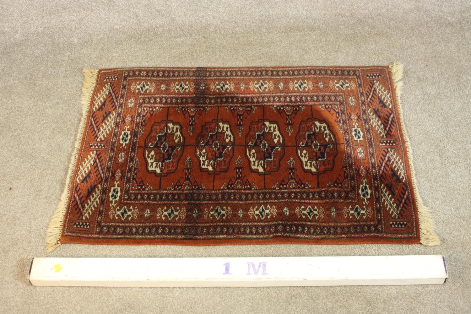 A hand made rust ground Bokara rug. L.92 W.54cm. - Image 2 of 4