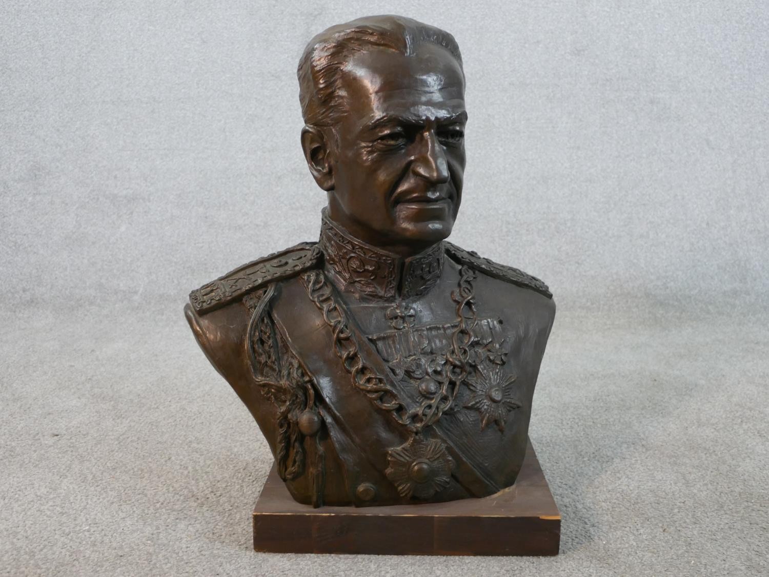 A cast bronze portrait bust of Persian Shah Mohammad Reza Pahlavi in military uniform, mounted on