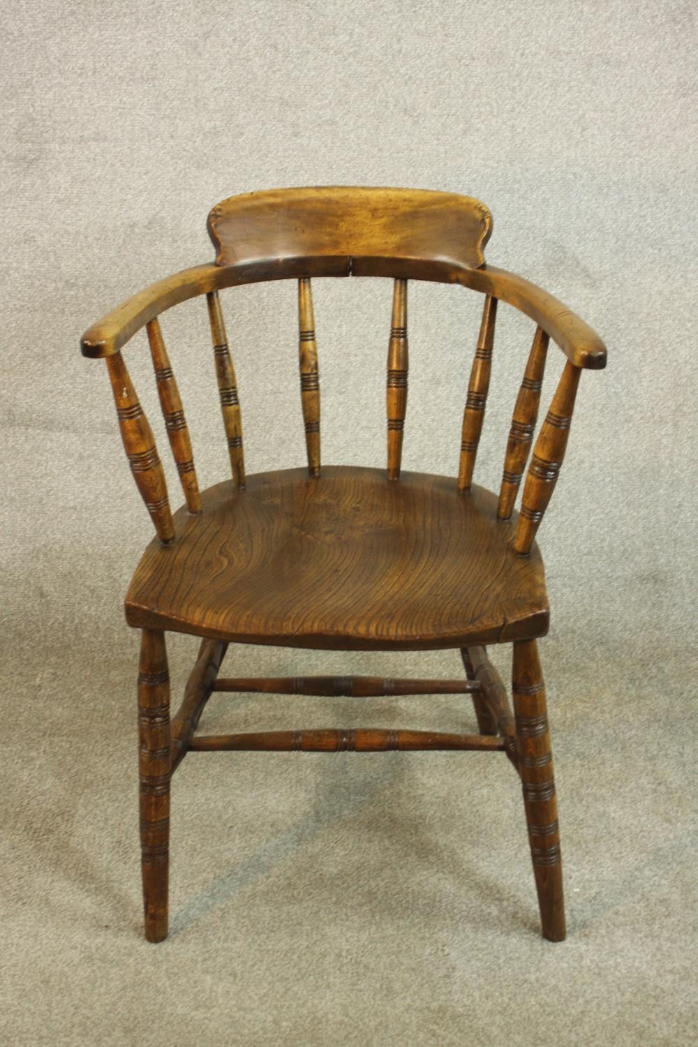 A 19th century captain's tub chair, the back on ring turned spindles, over an elm seat, on ring