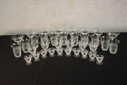 A collection of thirty six hand cut crystal glasses with an abstract star and foliate design,