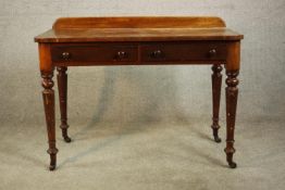 A Victorian walnut side table, with a gallery back over two short drawers with knob handles, on