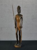 A carved hardwood African tribal statue with spear. H.67 W.18 D.13cm