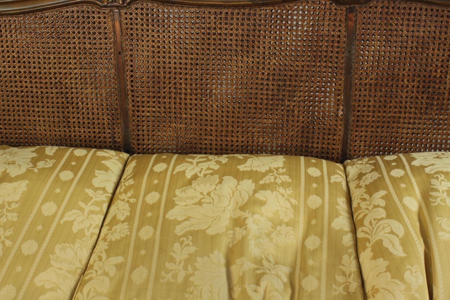 An early 20th century Continental carved walnut three seater bergere sofa, upholstered in gold - Image 12 of 18