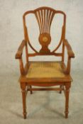 An early 20th century walnut and marquetry inlaid armchair, with a pierced splat back over a caned