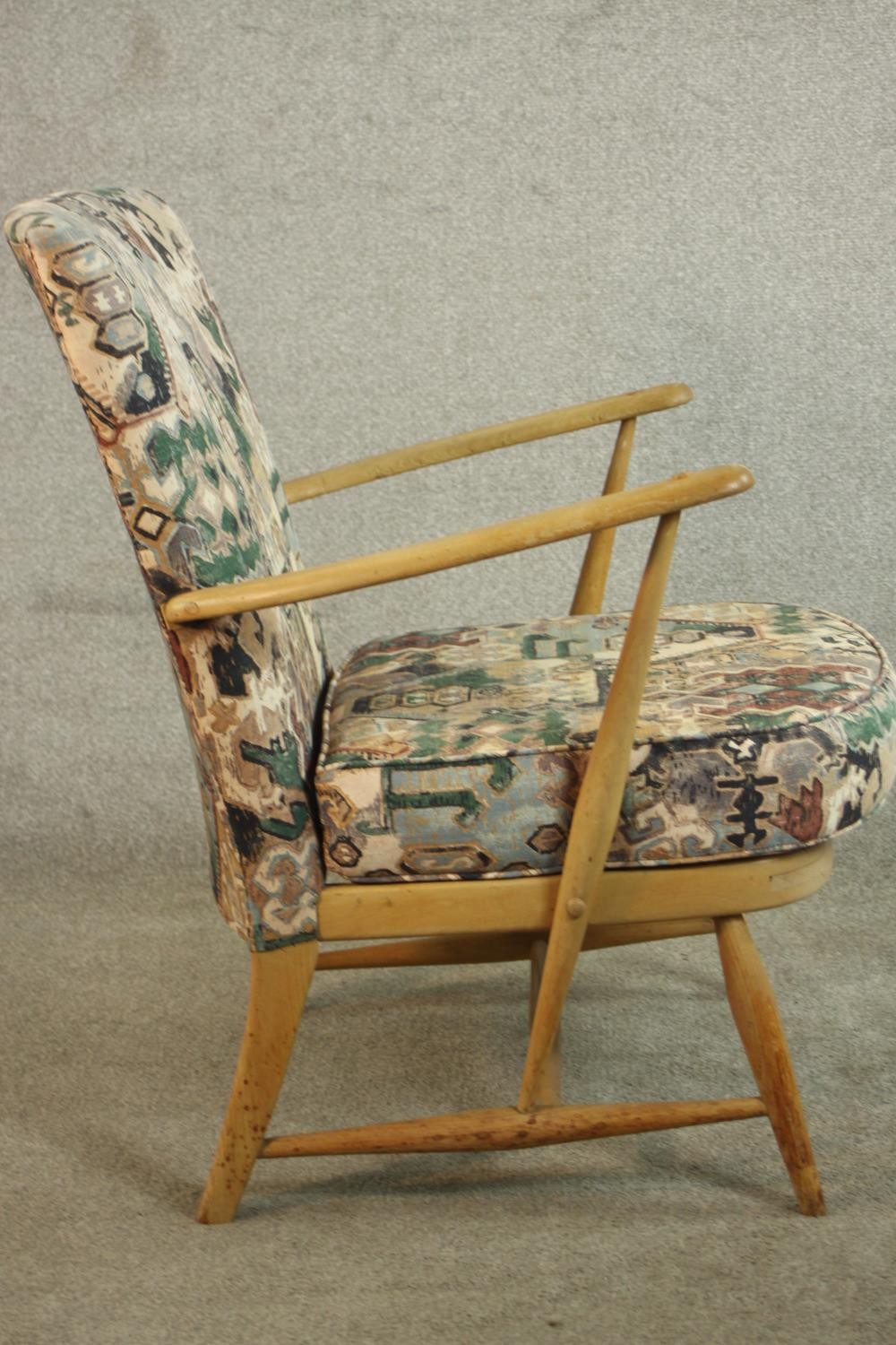 An Ercol beech armchair, with open arms, upholstered to the back and seat cushion. H.80 W.65 D.68cm. - Image 5 of 9
