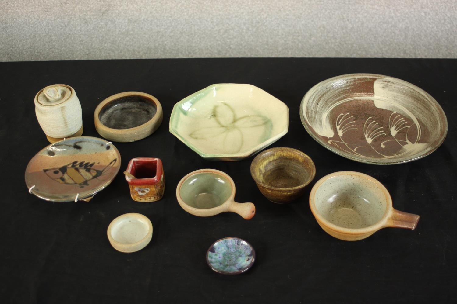 A collection of ten art pottery dishes and small bowls of various forms hand glazed with different