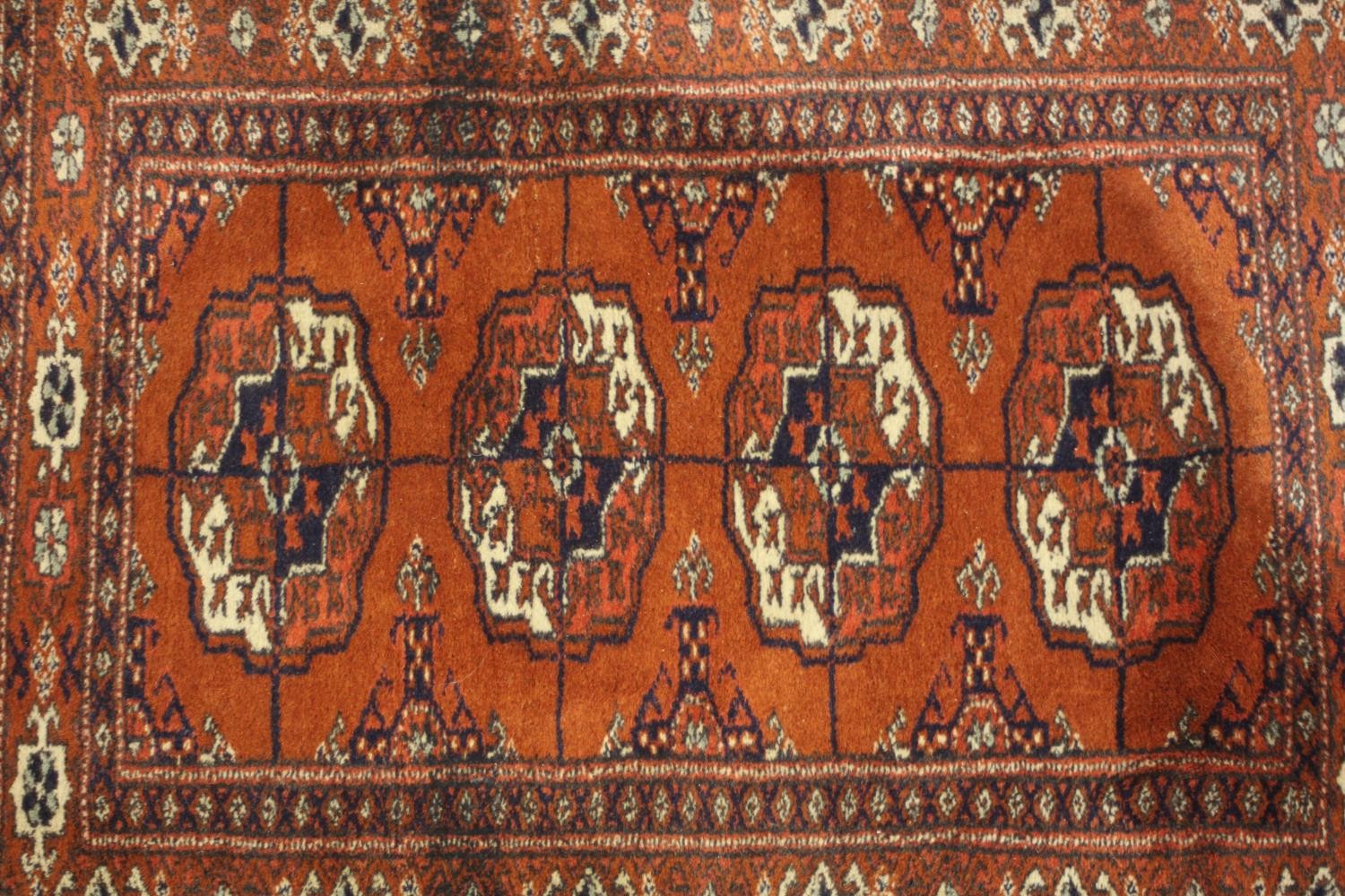 A hand made rust ground Bokara rug. L.92 W.54cm. - Image 3 of 4