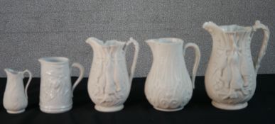 Five 19th century bisque porcelain relief design jugs, two with a game animal design, maker's