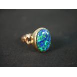 A red leather boxed synthetic opal and 9 carat gold dress ring. The ring box with a silver