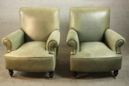 A pair of contemporary light green leather club armchairs, with scrolling arms, on turned legs