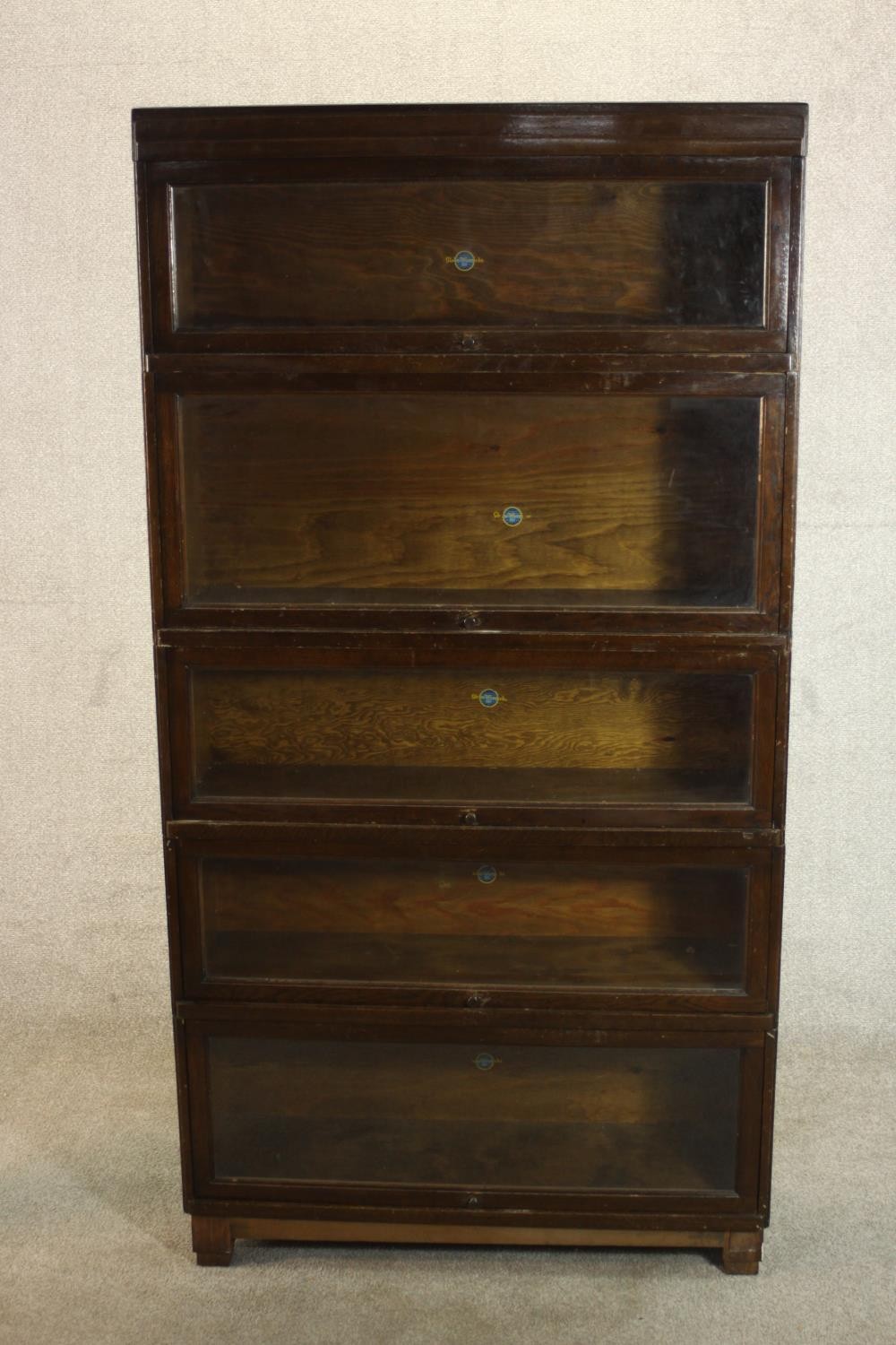 A mid 20th century Globe Wernicke oak stacking bookcase, the five sections with raising glass doors,