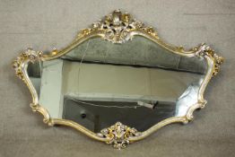 A contemporary Rococo style mirror, the silvered and parcel gilt carved wood frame with a
