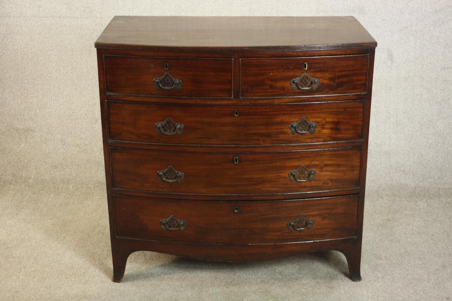 A George III bowfronted mahogany chest of two short over three long drawers above a shaped apron and