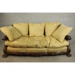 An early 20th century Continental carved walnut three seater bergere sofa, upholstered in gold