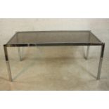 A 1970's dining table with a smoked plate glass top on a square section tubular chrome frame. H.74