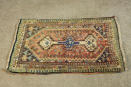 A hand woven red ground Persian Quashqai rug. L.88 W.53cm.