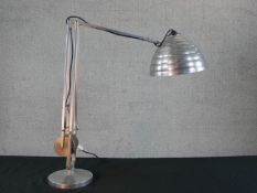 A brushed steel electric desk top angle poise style lamp, on circular foot. H.67 W.58cm