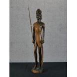A carved hardwood African tribal statue with spear. H.67 W.18 D.13cm