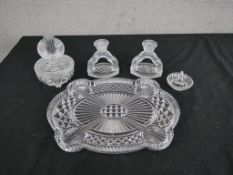 An Art Deco cut glass dressing table set, including a pair of candlesticks, ring holder, lidded